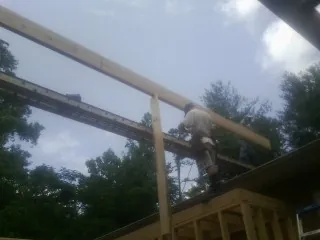 Carpenter setting a ridge beam over a new addition frame — Ice Dam Removal by Roofing Brothers in Fort Mc Coy