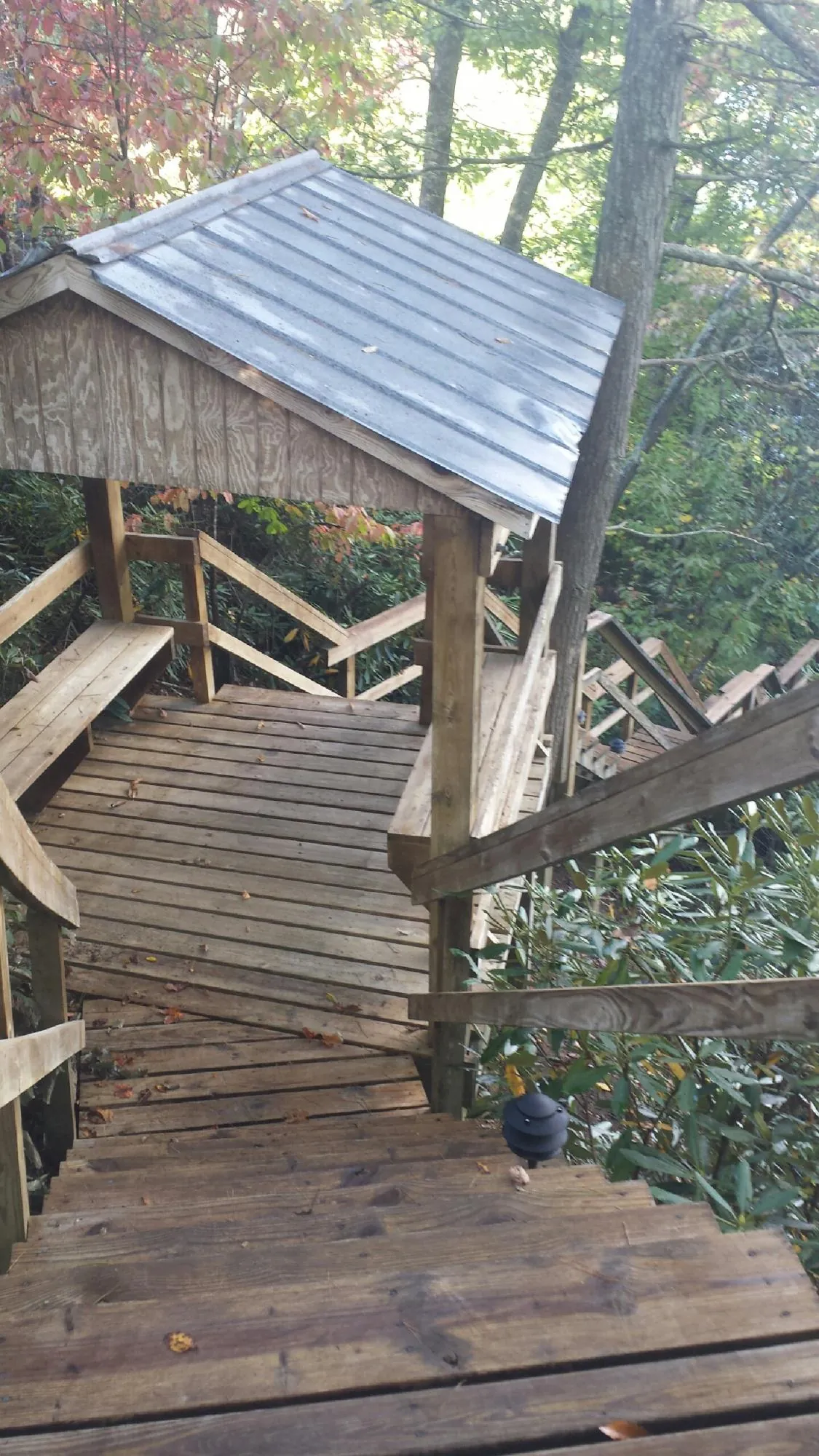 Metal roofed shelter over wooden steps on a wooded walkway in Fort Mc Coy
