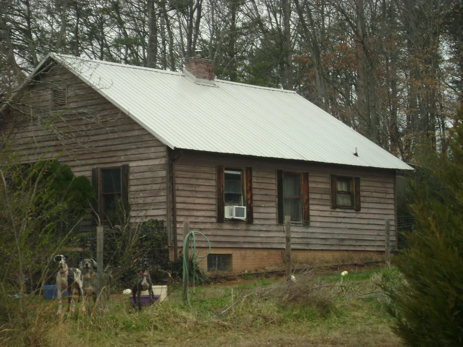 White metal roof on an old wood sided farmhouse, from a Metal Roof Installation job in Fort Mc Coy